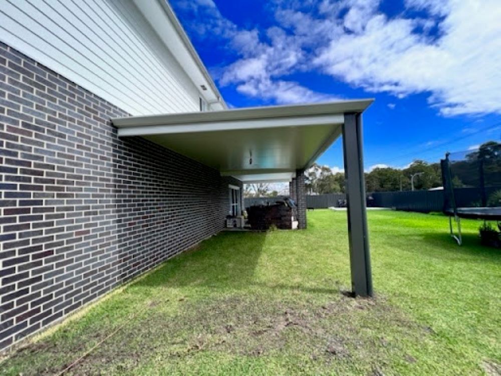 A Brick House With a Covered Area in the Backyard — Outdoor Leisure Living In Lake Macquarie, NSW