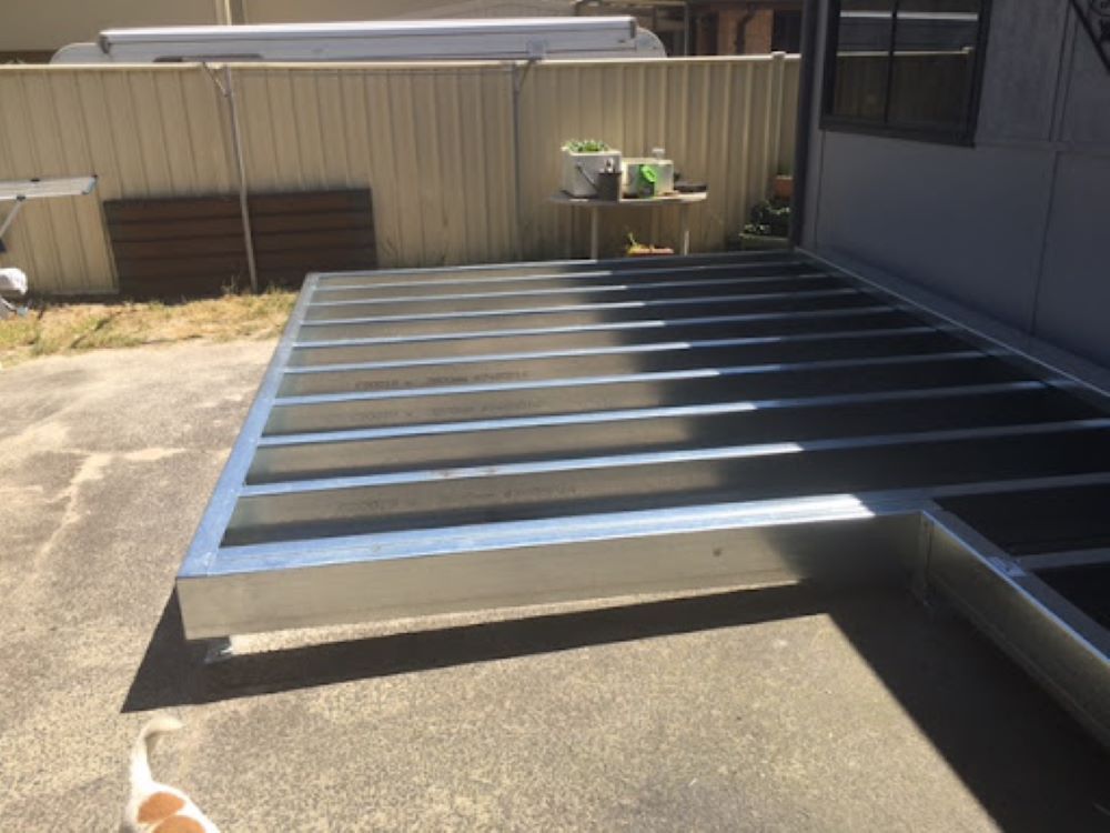 A Cat is Standing Next to a Metal Deck in a Driveway — Outdoor Leisure Living In Lake Macquarie, NSW