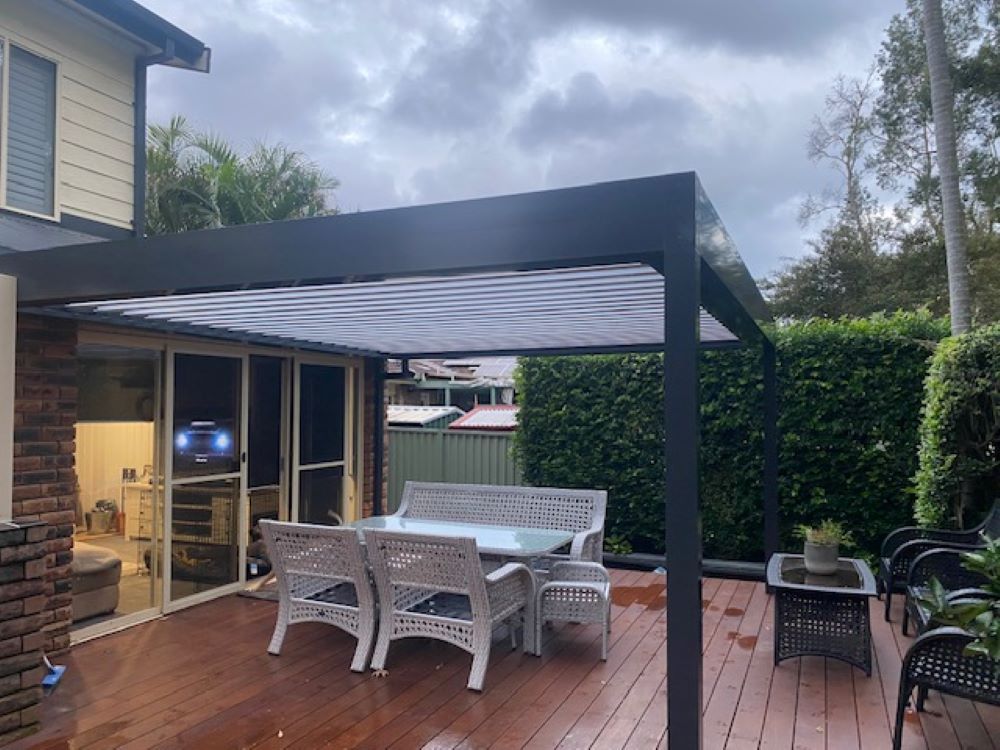 A Patio With a Table and Chairs Under a Pergola — Outdoor Leisure Living In Tuggerah, NSW