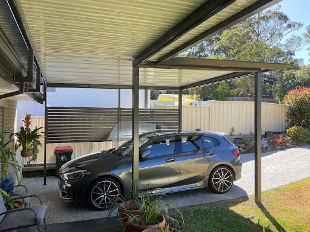 A Car is Parked Under a Canopy in a Driveway —Outdoor Leisure Living In Tuggerah, NSW