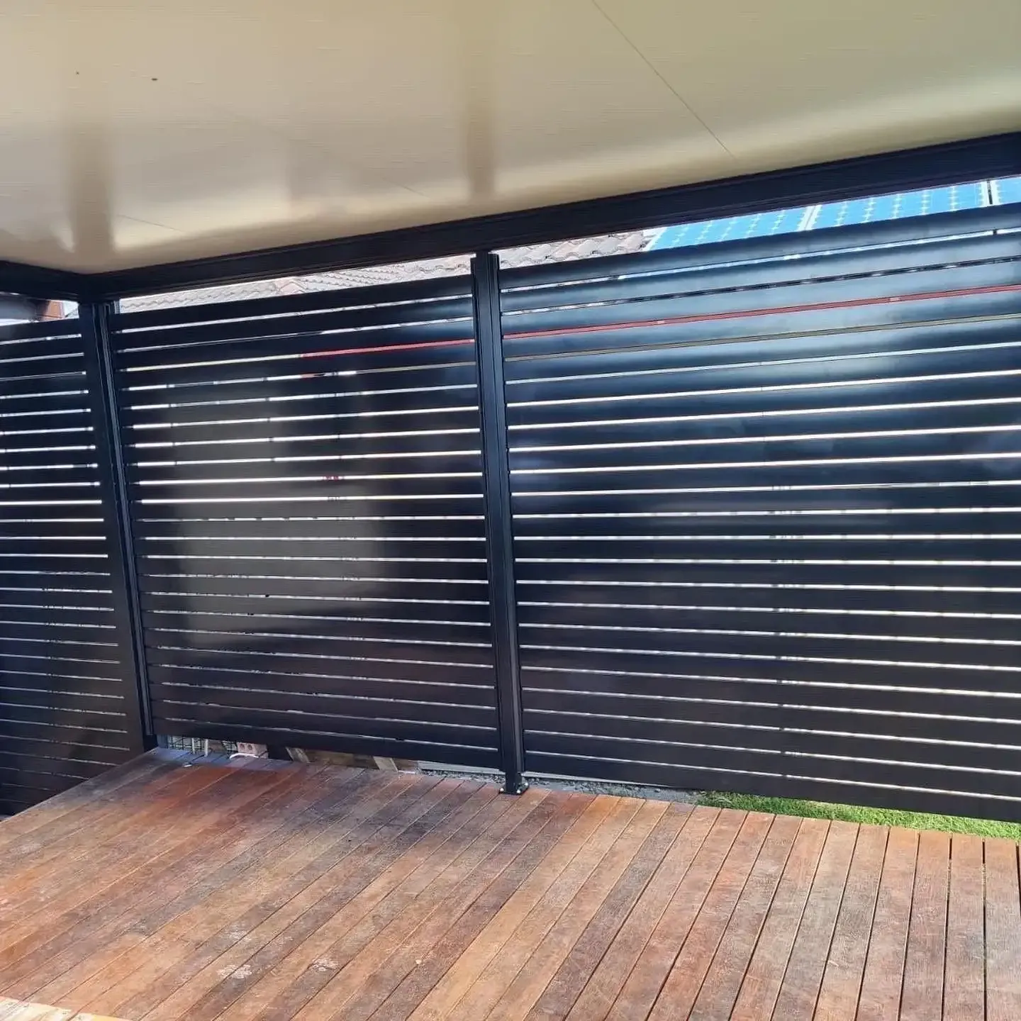 A wooden deck with a black privacy screen — Outdoor Leisure Living In Tuggerah, NSW