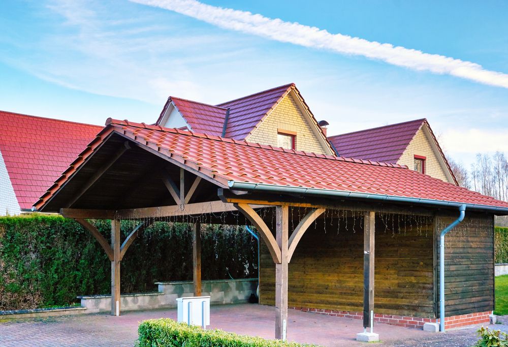 Wooden Carport with Red Tile Roof Next to a Wooden Building
