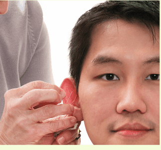 A man is getting his ear examined by a woman
