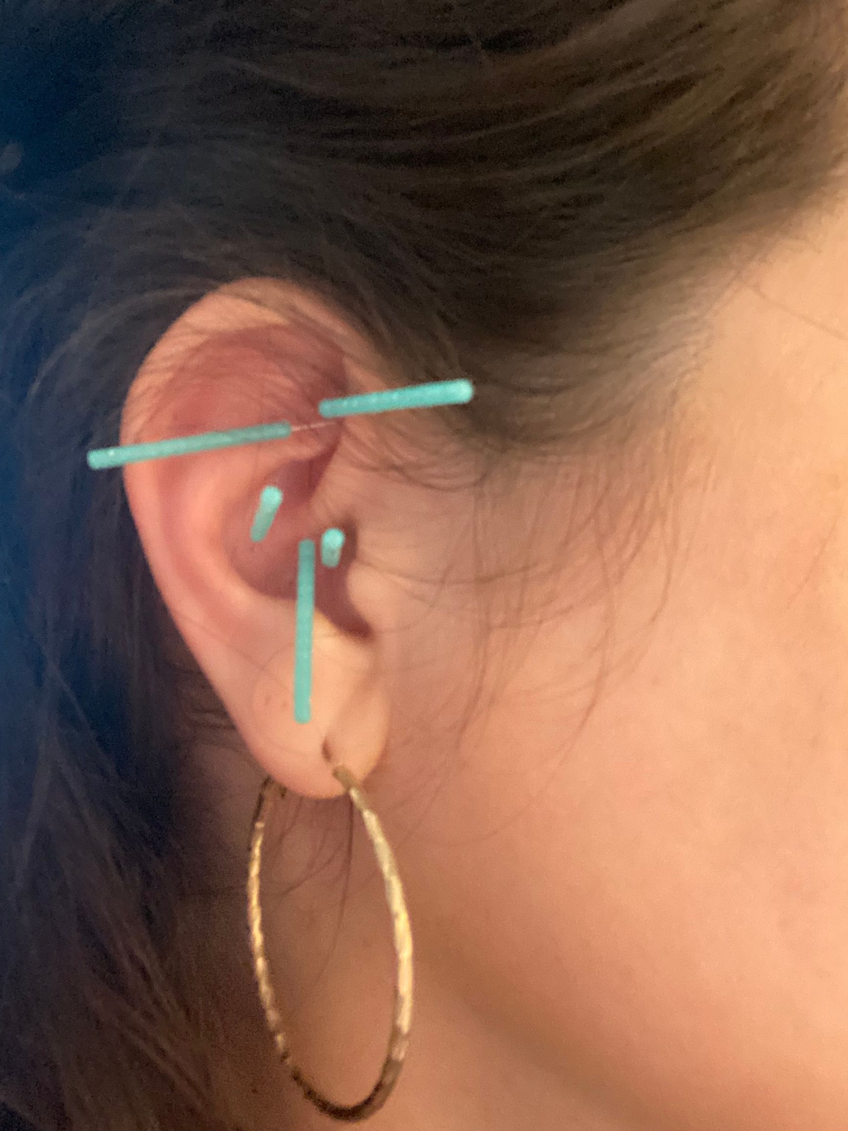 A close up of a woman 's ear with hoop earrings
