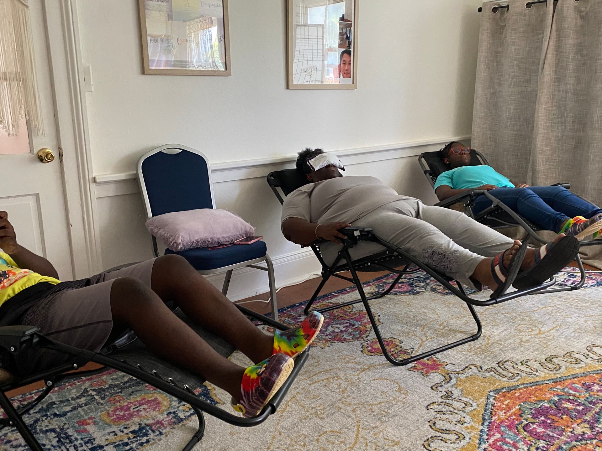 Three people are laying in chairs in a living room.