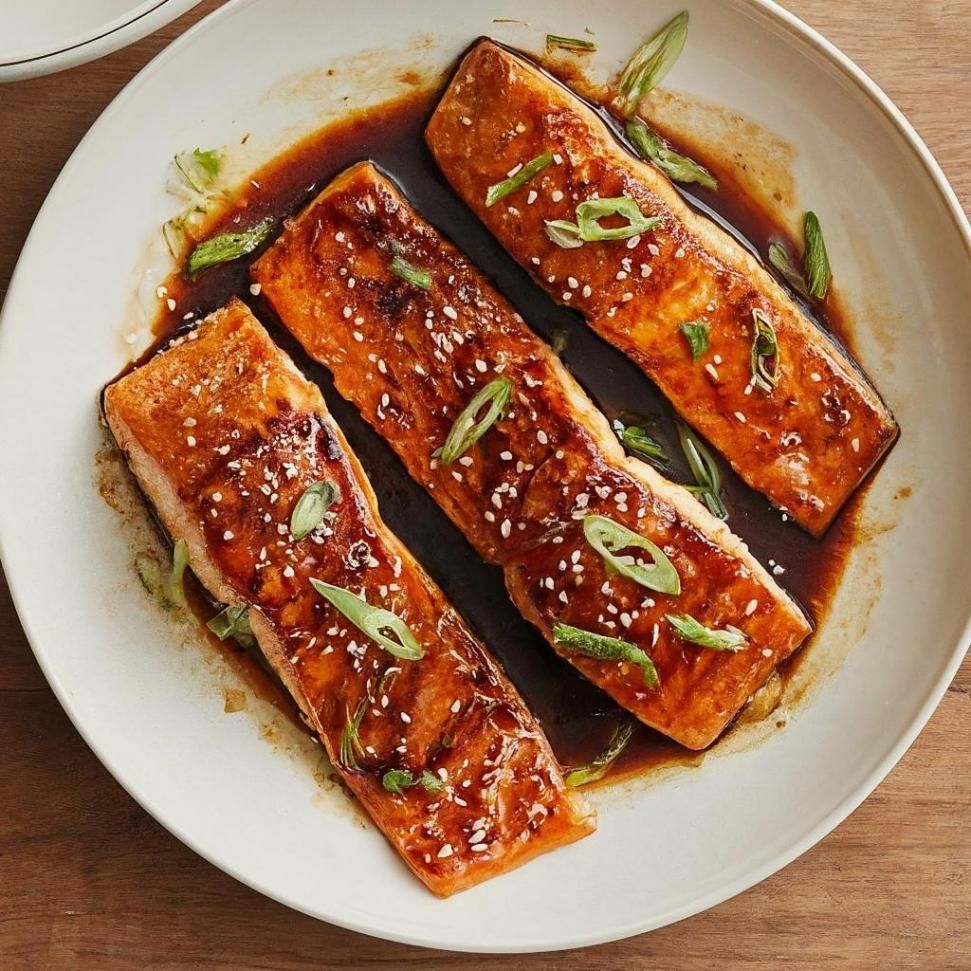 A White Plate Topped With Three Pieces Of Salmon Covered In Sauce And Green Onions — Northern Rivers