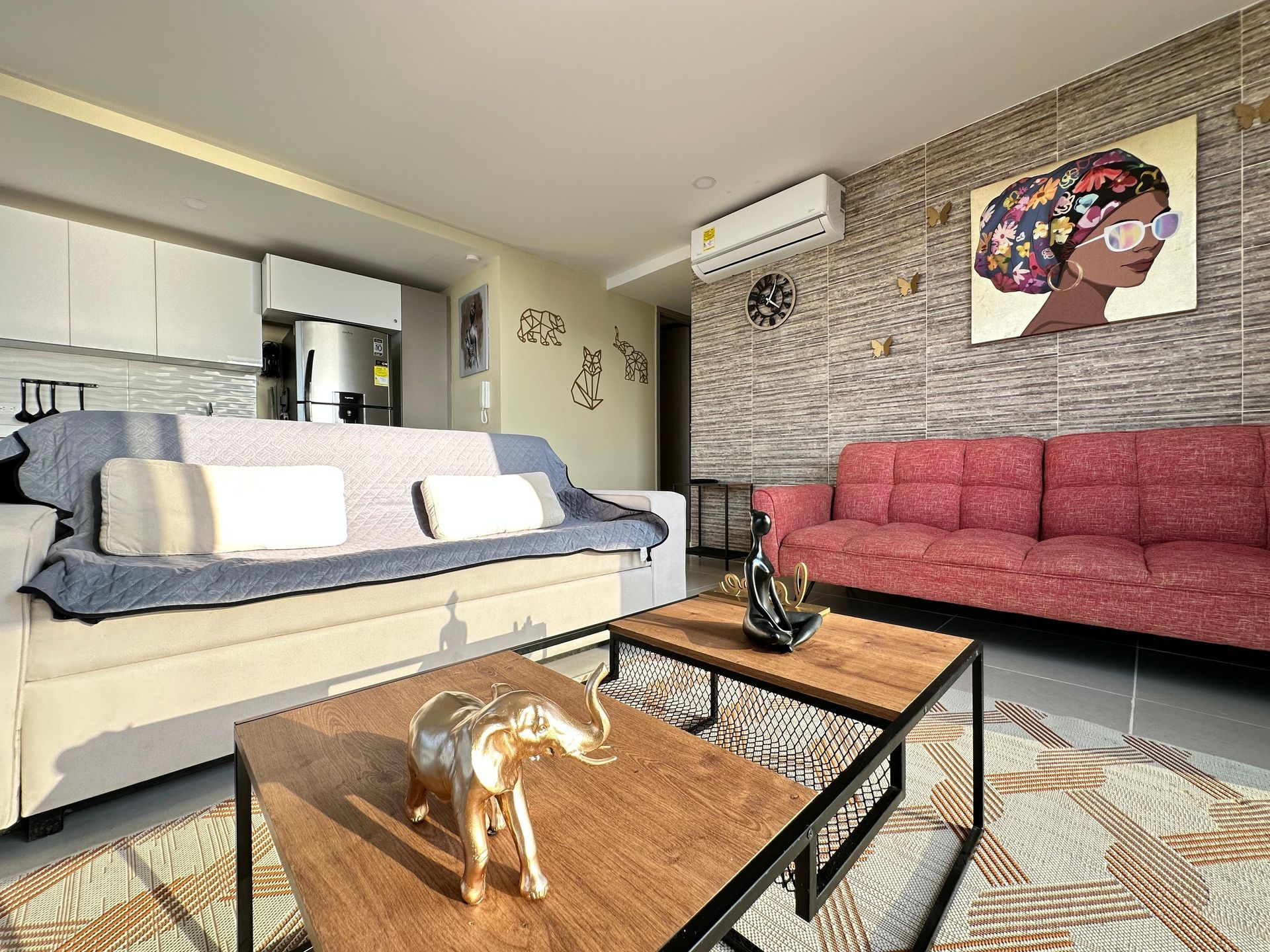 Sala de estar con dos mesas de café, sofás y una decoración de pared.  | Mevak Agency