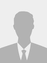Persona sonriente con traje y corbata, sobre un fondo claro. | Mevak Agency