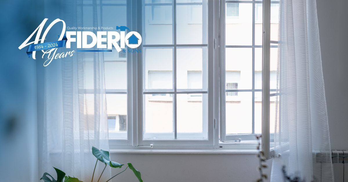 Minimalist bright room with large white-framed window and sheer curtains, logo in top left.