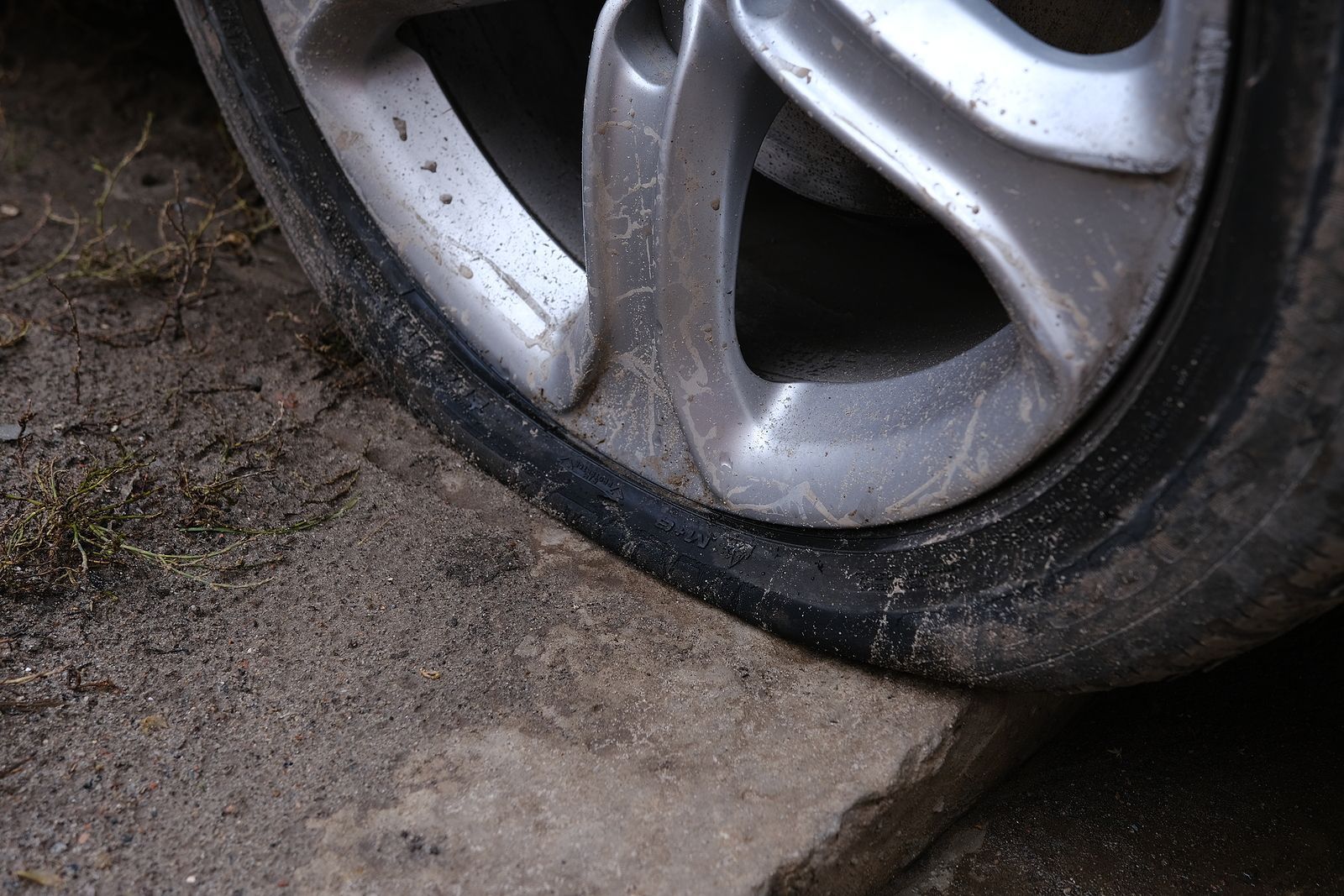 A close up of a flat tire on a car.