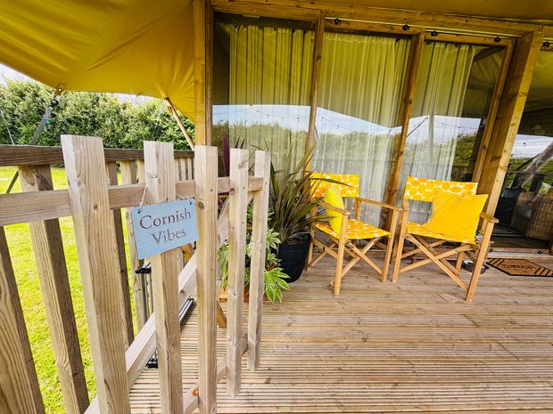 Wooden porch with chairs and sign that says 