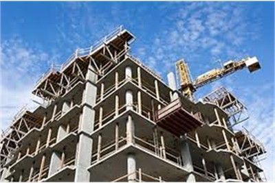 Construction site of a multi-story building under construction; a crane against a blue sky.