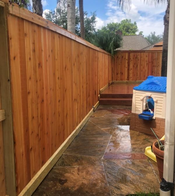 Aged wooden fence near new lumber boards.