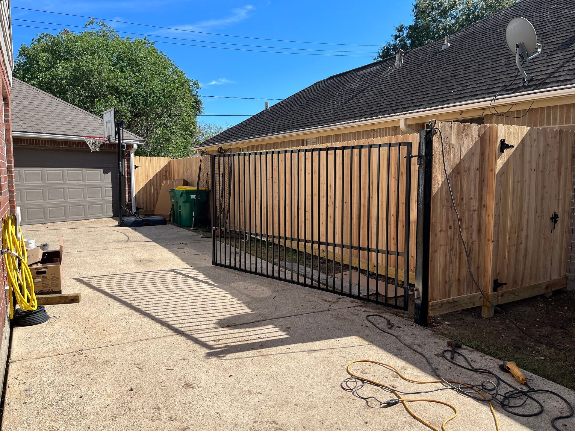 Stack of vertical slat replacement fence panels in a residential backyard, prepared for installation.