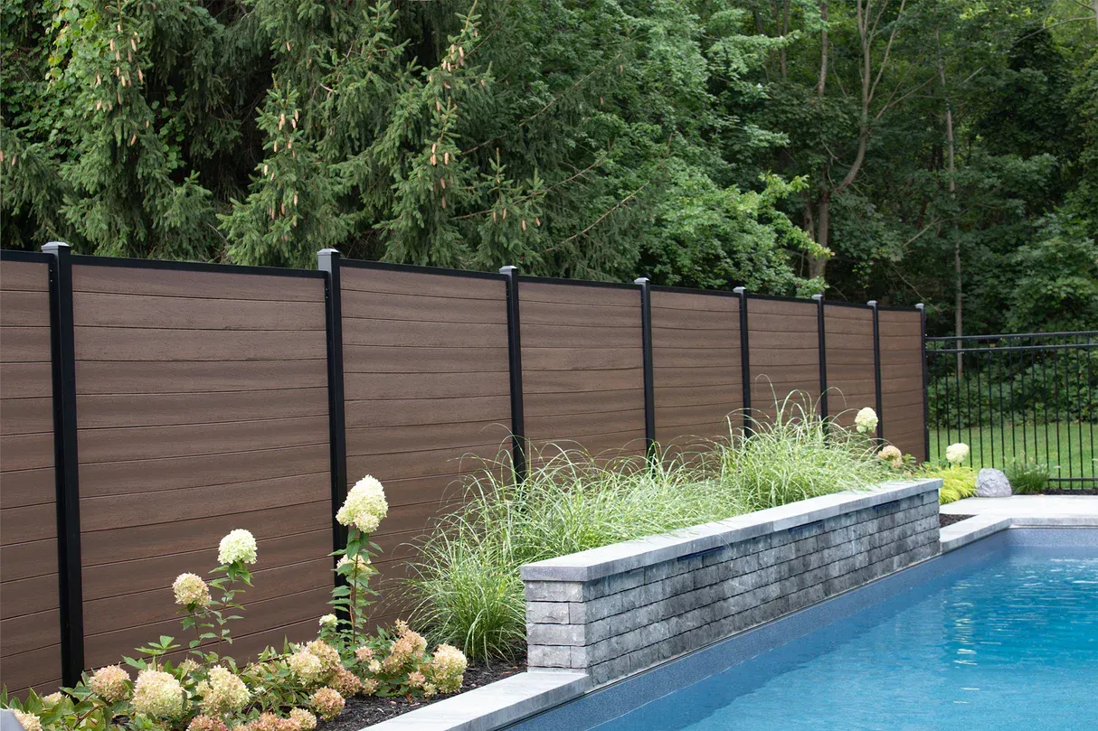 Aged wooden fence near new lumber boards.