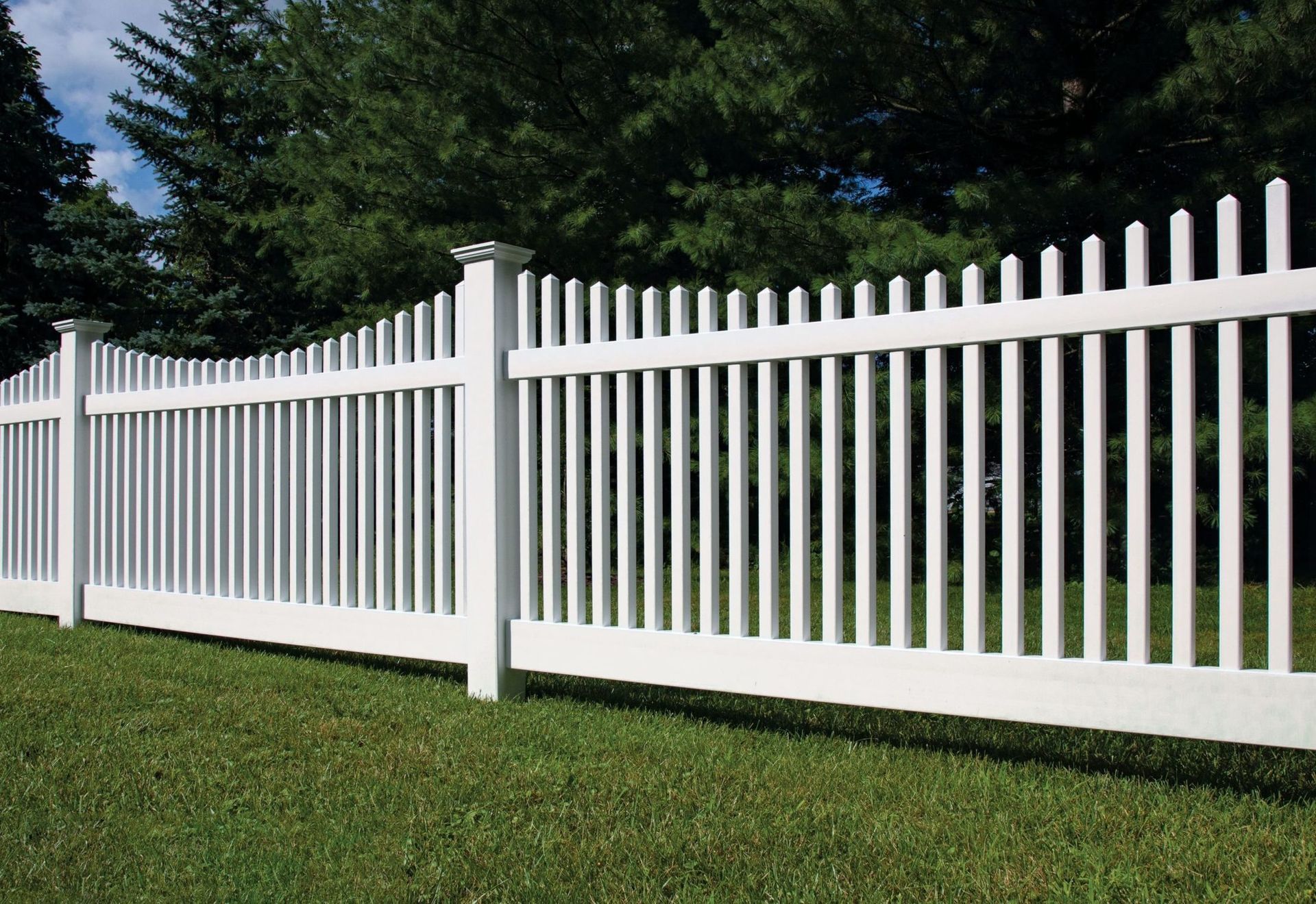 Stack of vertical slat replacement fence panels in a residential backyard, prepared for installation.