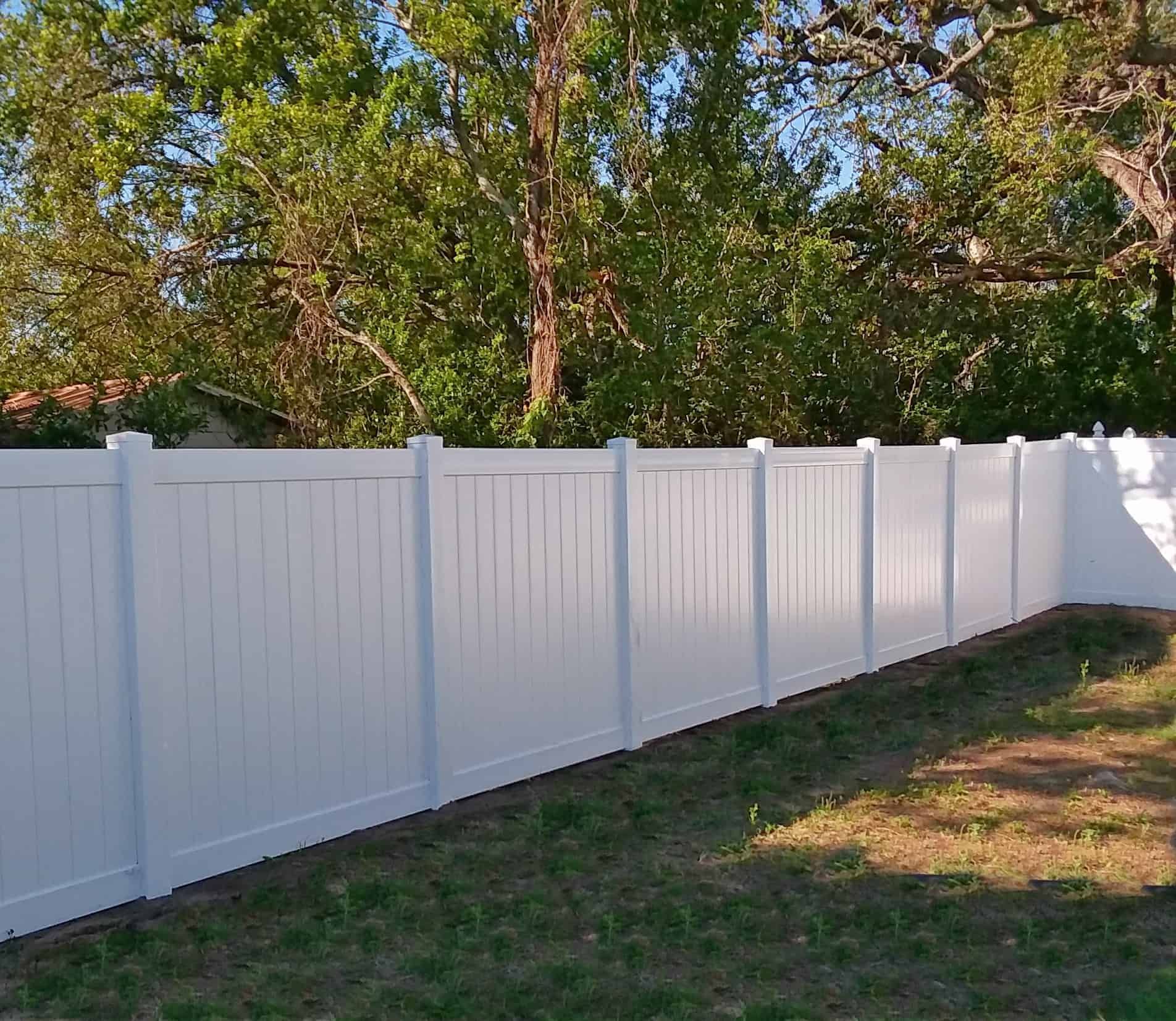 Aged wooden fence near new lumber boards.