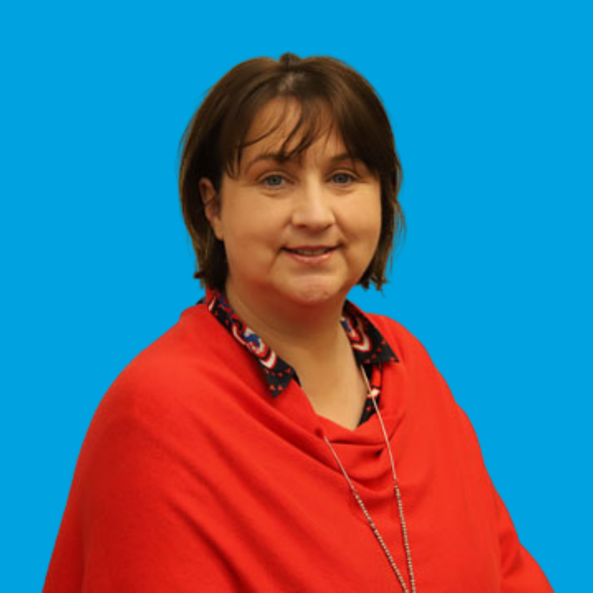 Woman in a red shawl posing against a bright blue background