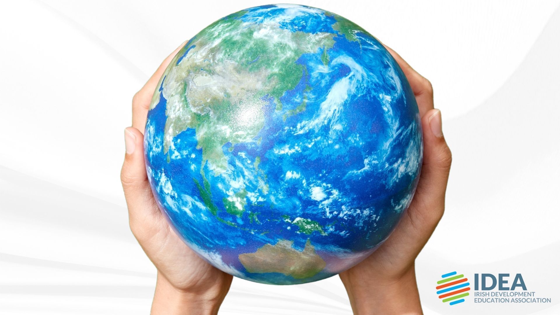 Hands holding a blue-green globe on a white background, with an IDEA logo in the corner.