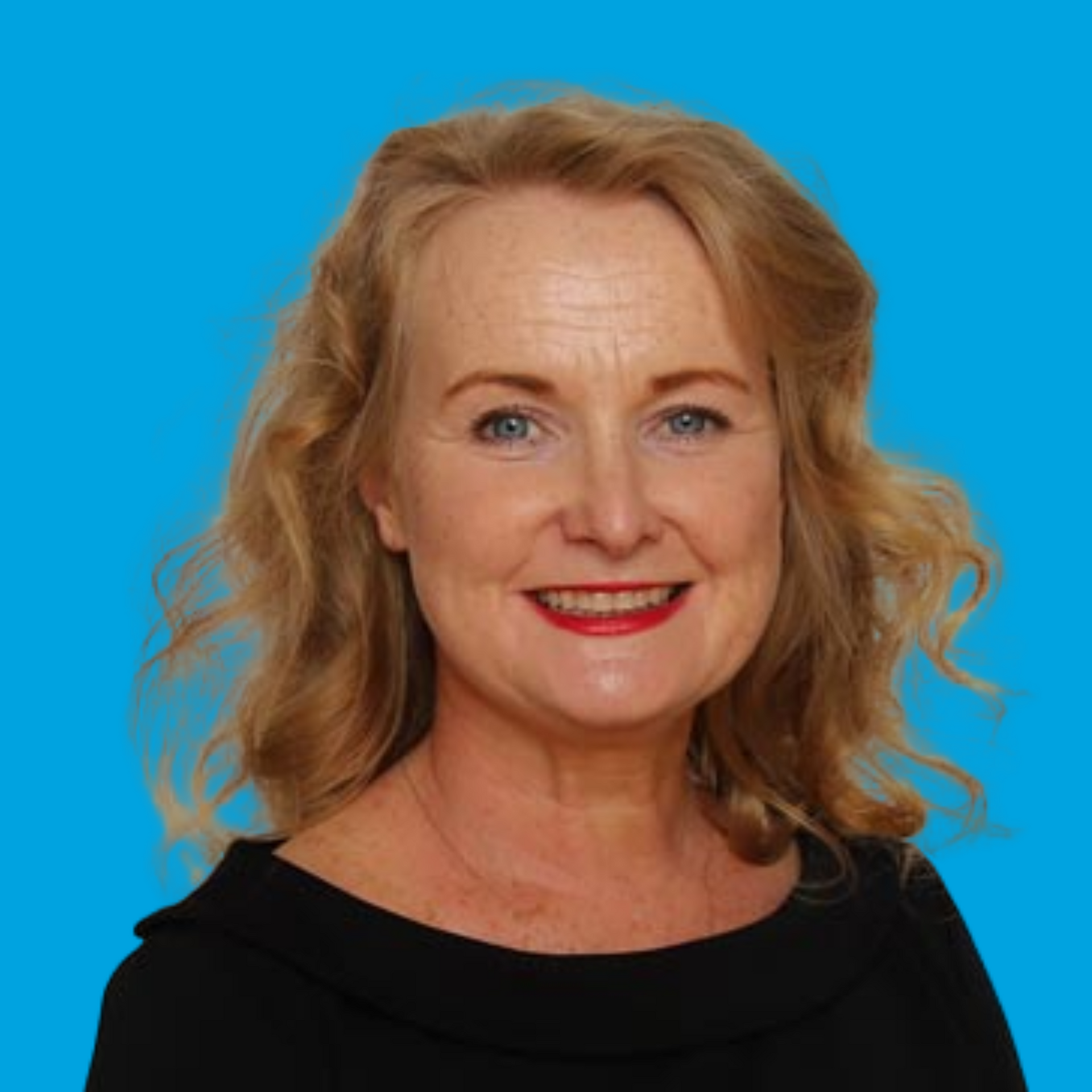 Smiling blonde woman with wavy hair against a bright blue background