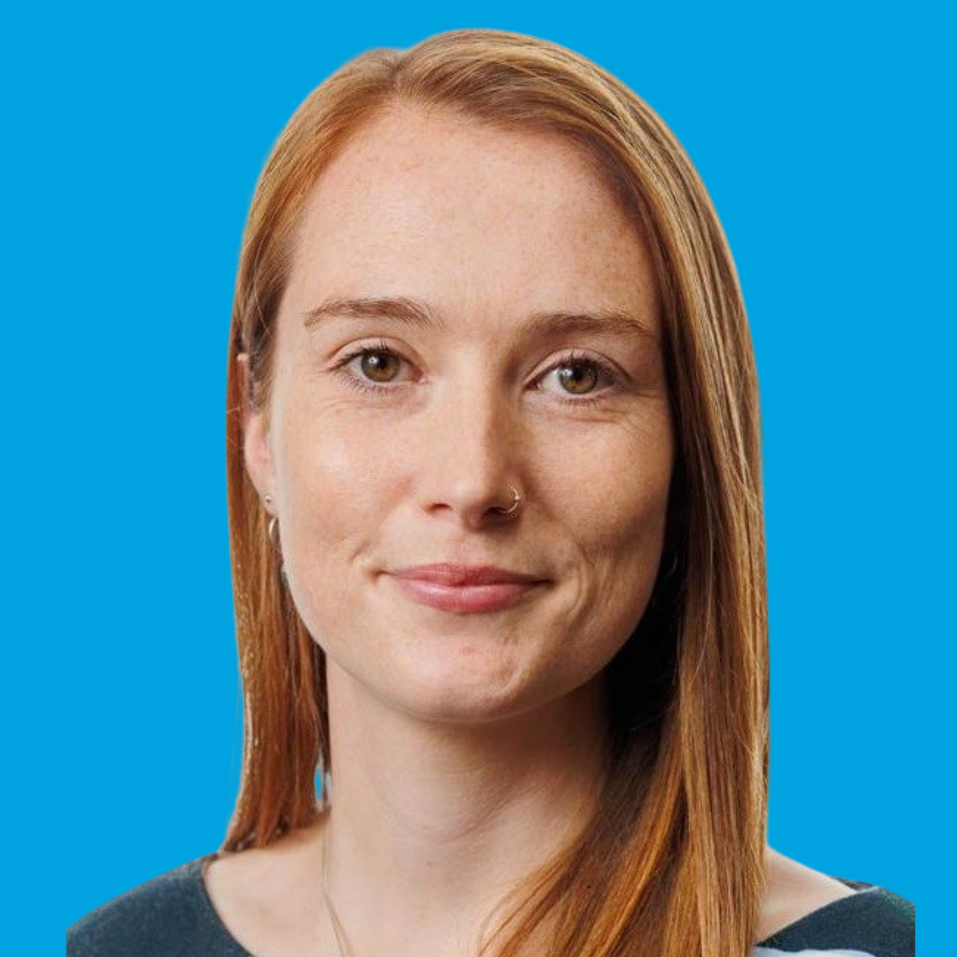 Portrait of a smiling woman with red hair against a bright blue background