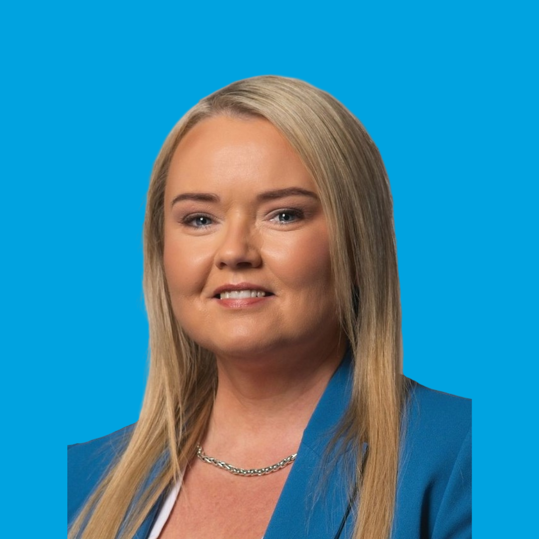 Portrait of a smiling woman in a blue blazer against a bright blue background