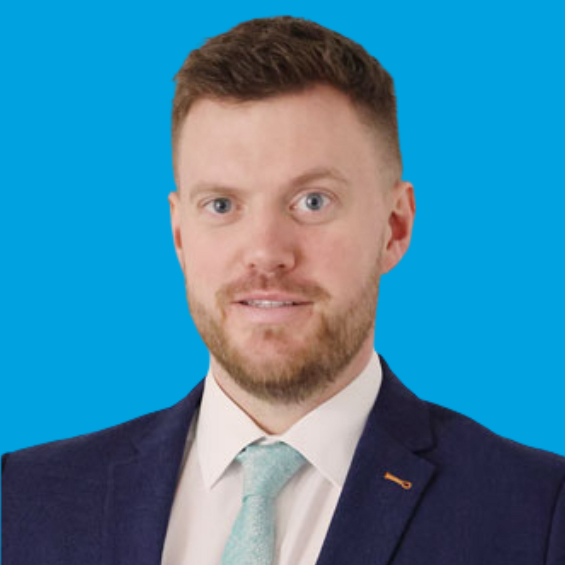 Portrait of a man in a navy suit and light tie against a bright blue background