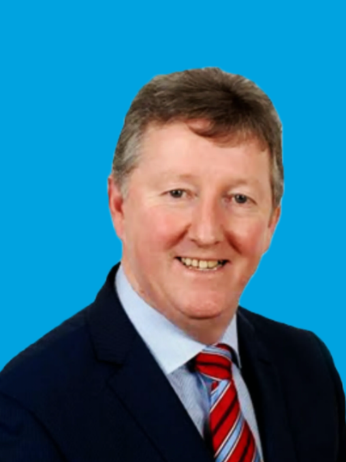 Portrait of a smiling man in a dark suit and red striped tie on a blue background
