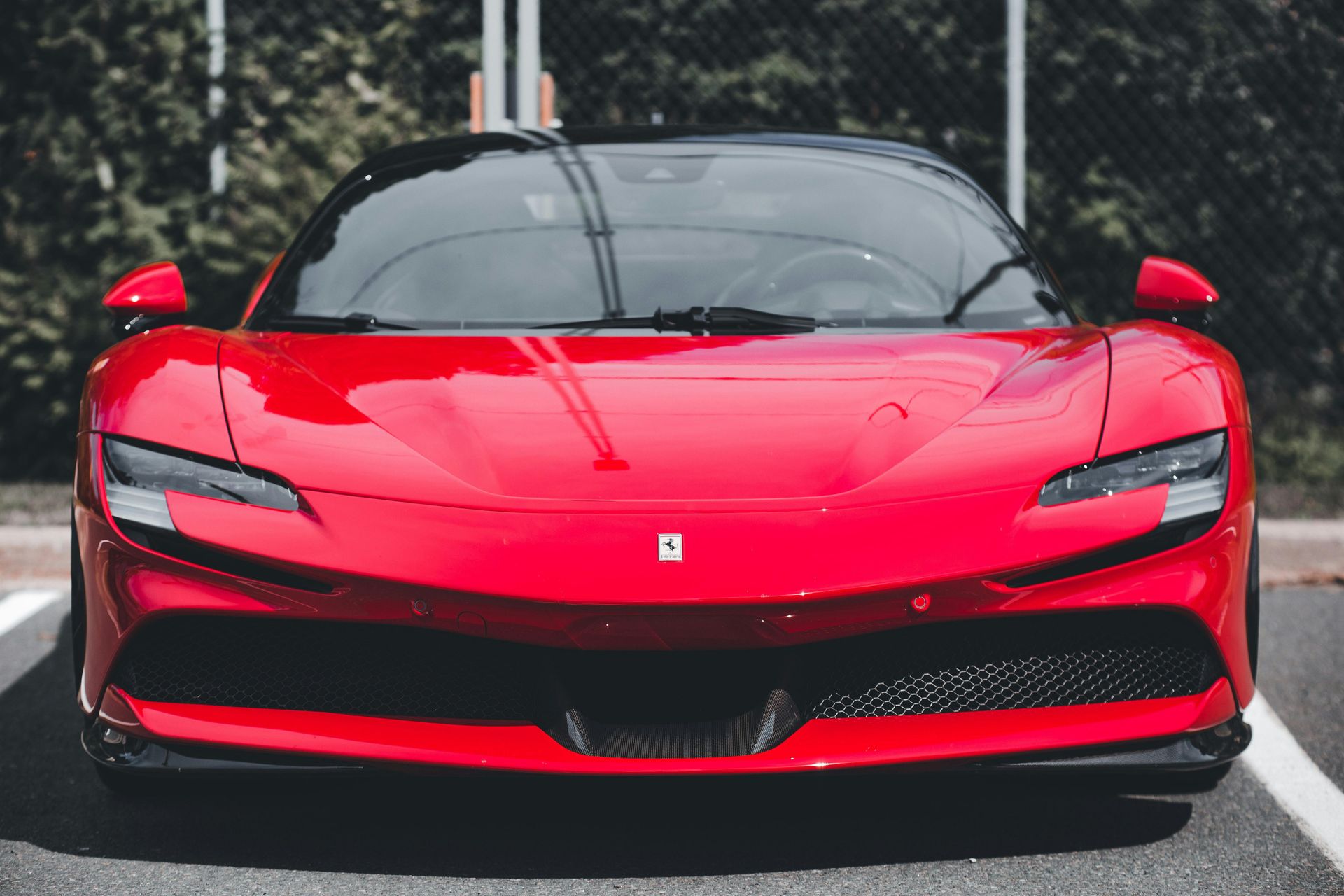 Person wearing black gloves applying ceramic coating to red car.