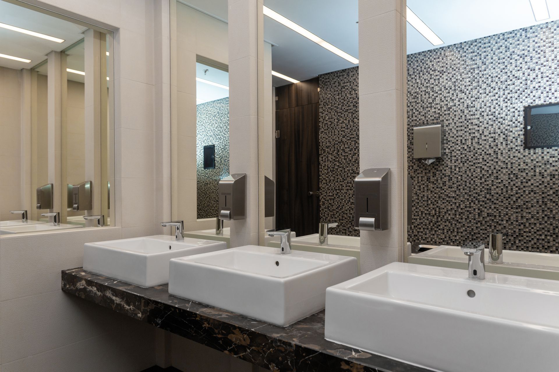 A bathroom with a lot of sinks and mirrors.