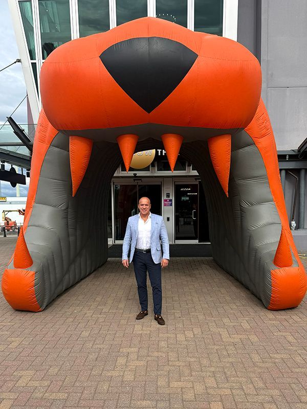 Frank Melo of Summit Steel Buildings in mouth of BC Lions inflatable mascot.