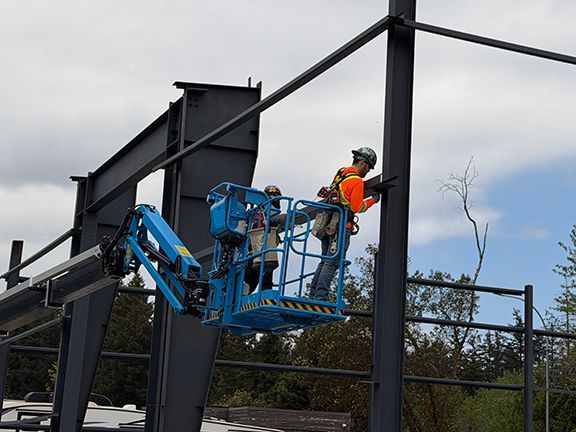 Skilled tradesman adds support beams to steel framing