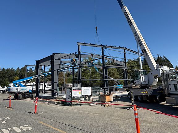 Steel crossbeams are lowering into place using elevator lifts