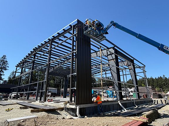 The first metal wall panels are added using a crane lift