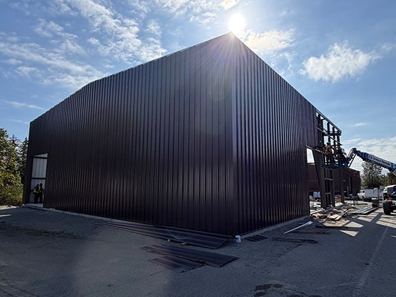 Sun shines behind a pre-engineered metal building construction site
