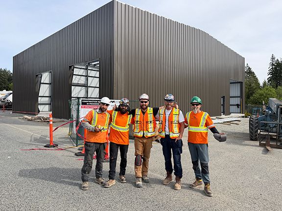 Construction team stands outside Summit Steel Buildings PEMB project