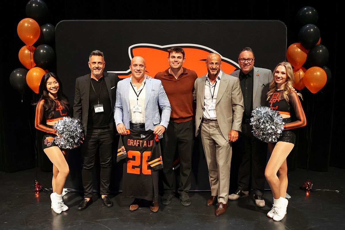 Summit Steel Buildings management team poses with Nathan Rourke and other teammates of the B.C. Lions.