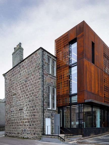 Metal building with a worn finished added beautifully to older brick building.