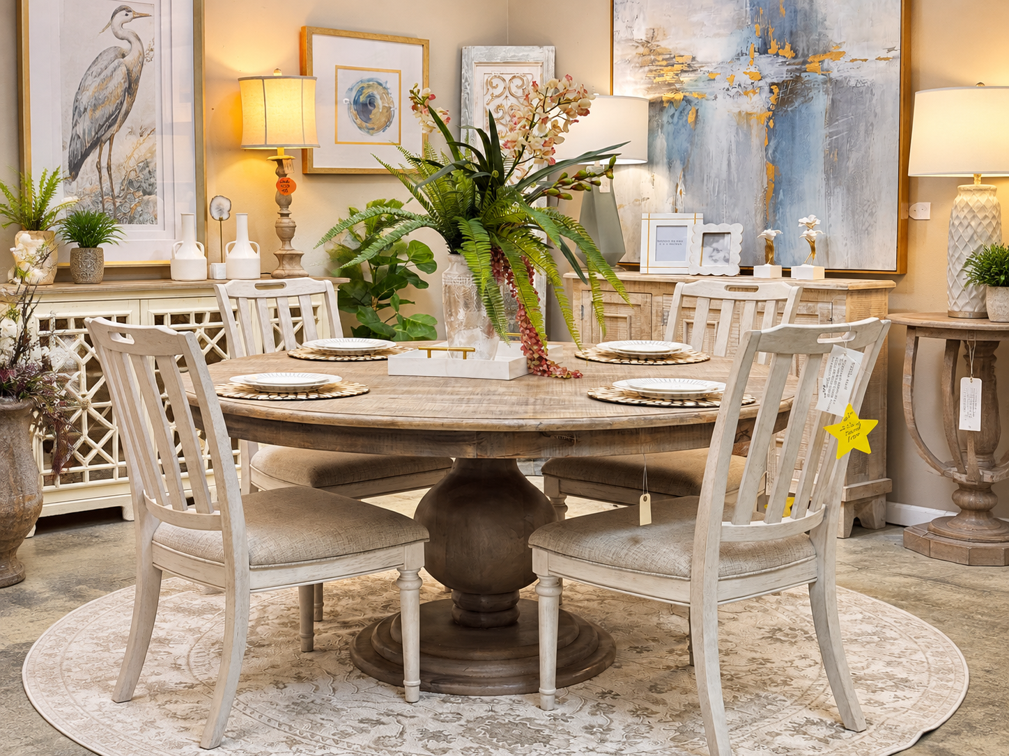 Dining room with wooden table and chairs, centered decor, and a couch in the background.