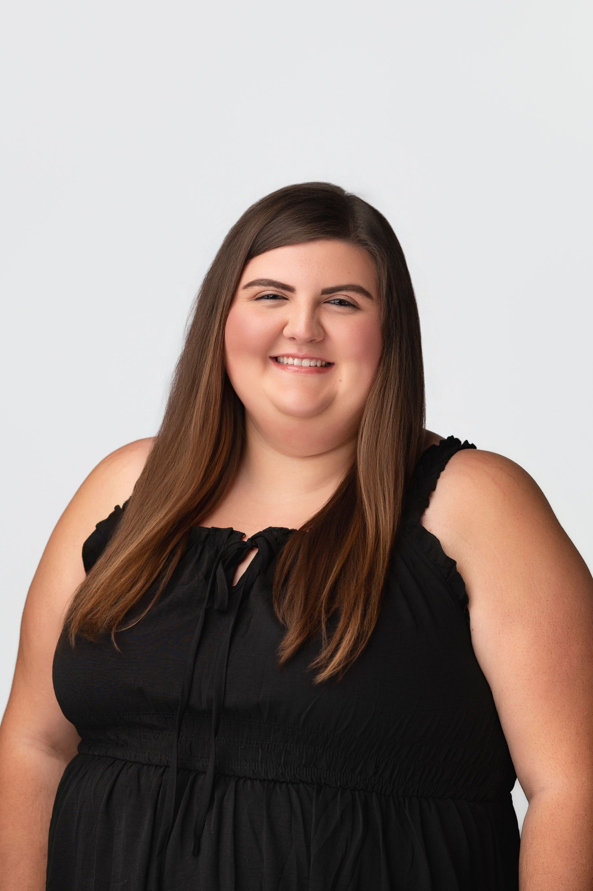 A woman in a black dress is smiling for the camera.