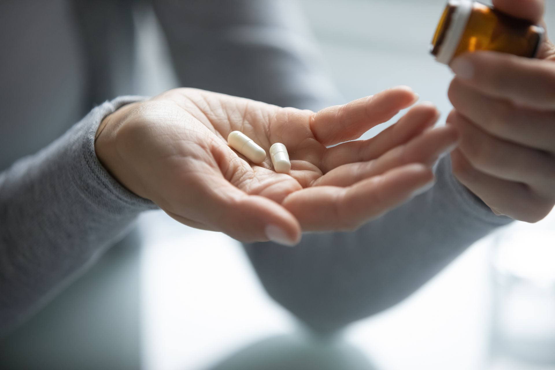 a person is holding two dental sedation pills