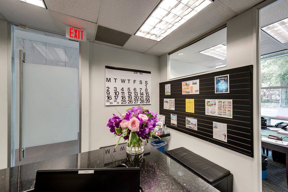 an office with a red exit sign and a calendar on the wall