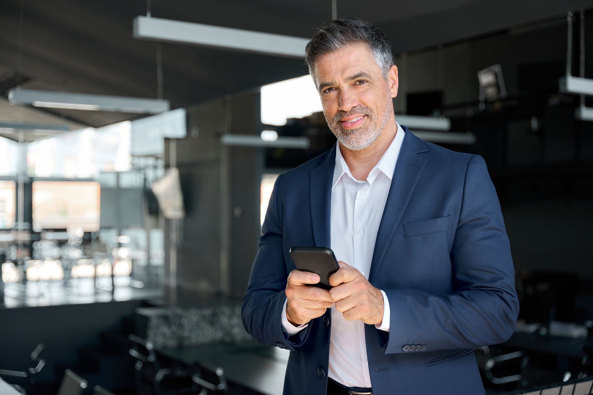 a man in a suit is holding a cell phone