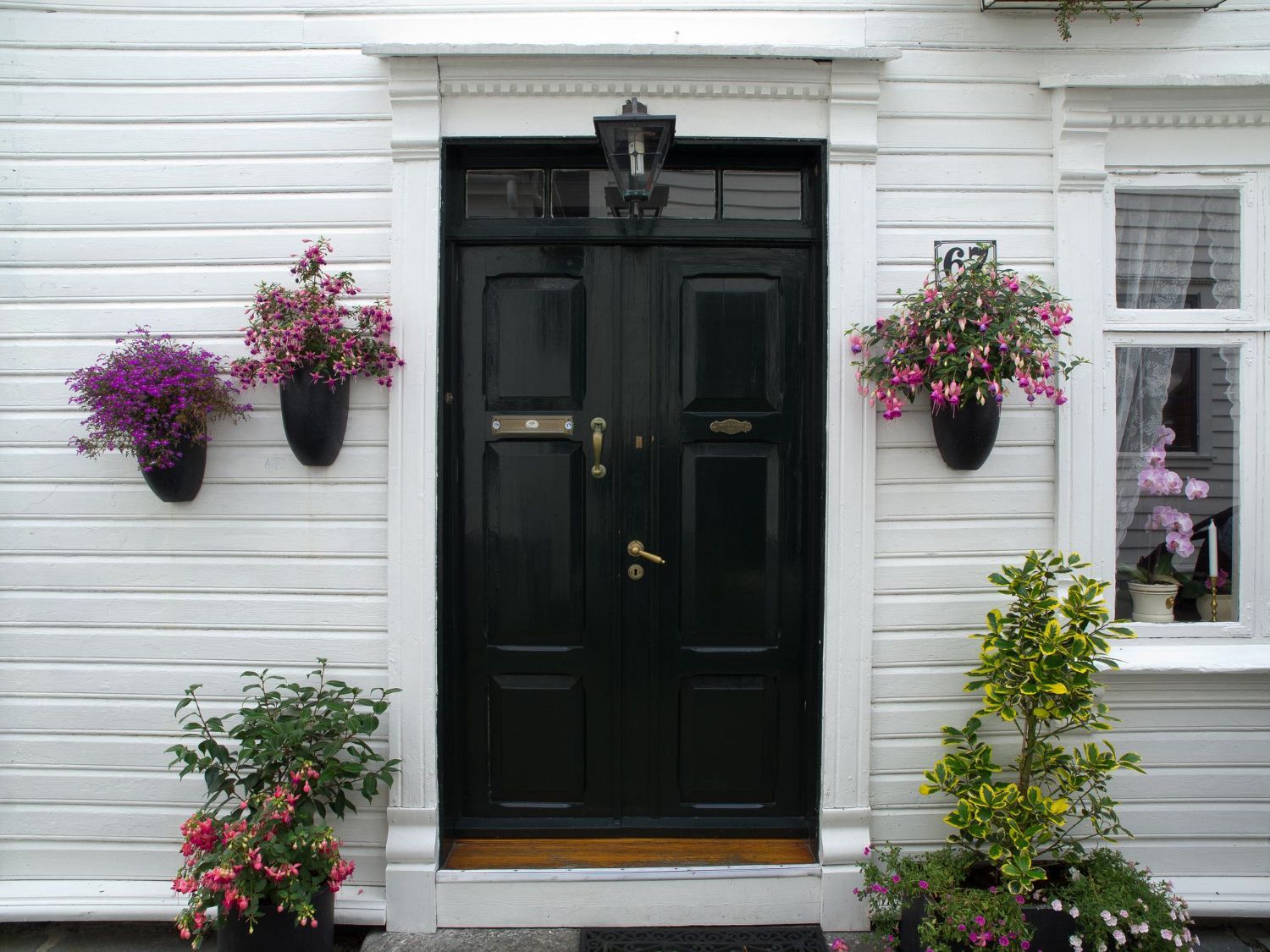The front door of a white house with a black door