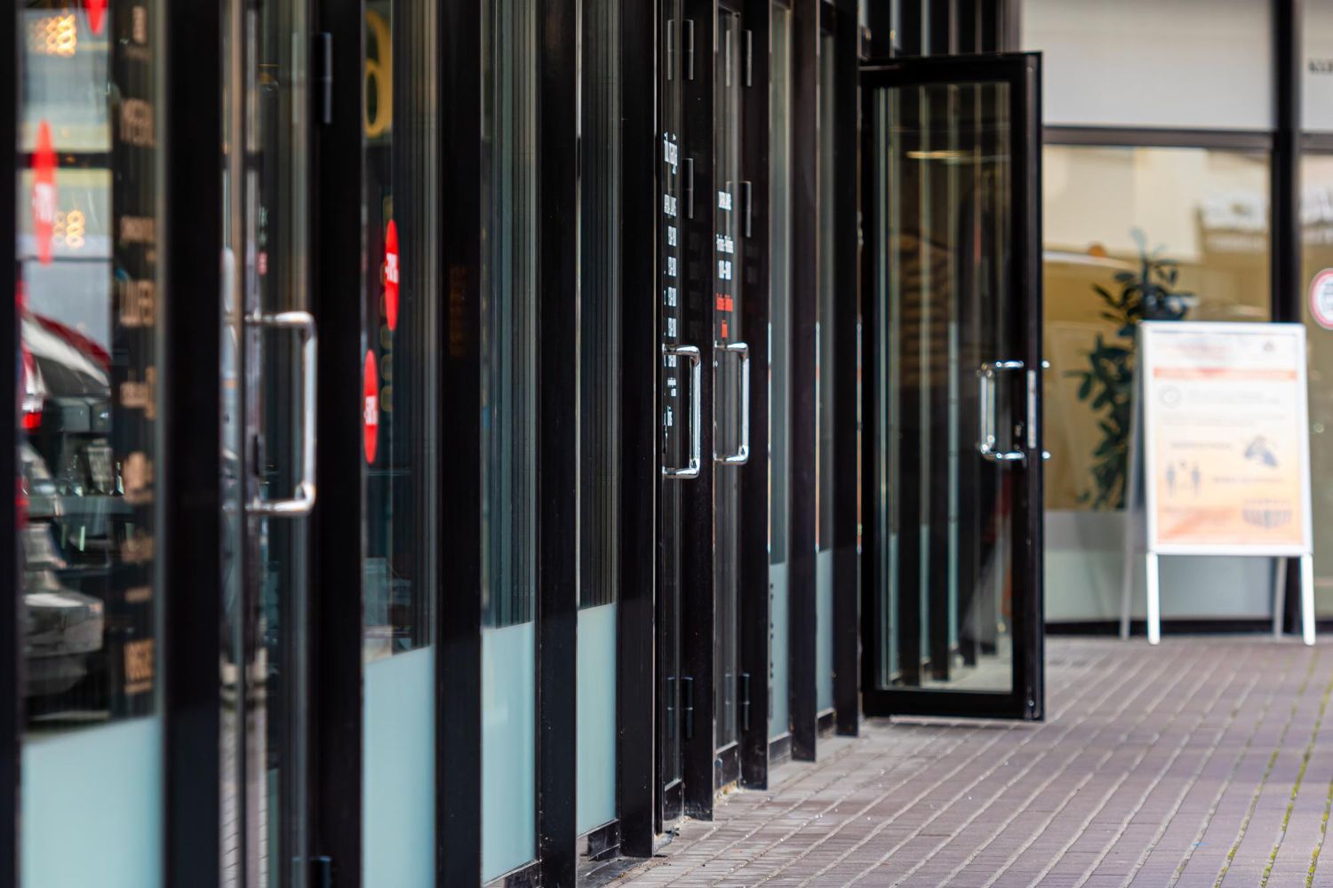 A row of glass doors leading to a building.