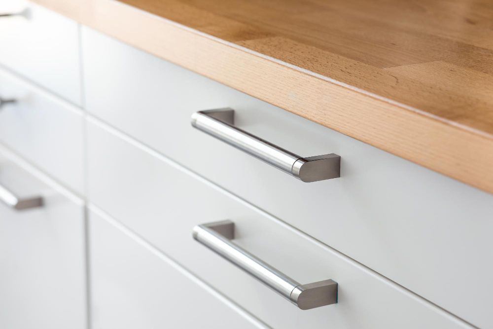 A close up of a door handle on a white door.