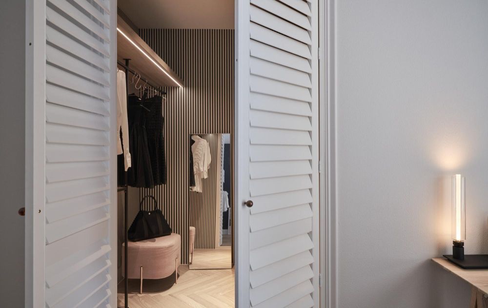 A hallway in an office building with sliding glass doors and a chair.