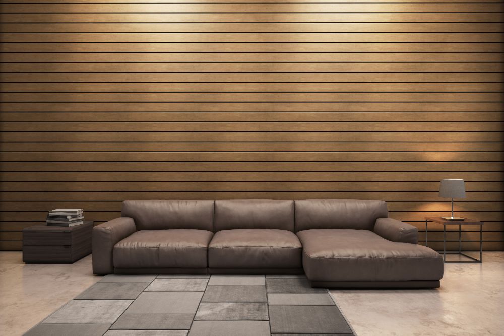 A living room with a couch and a kitchen with black cabinets.