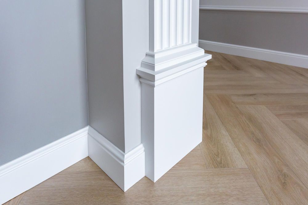 An empty hallway with white walls and a black door.