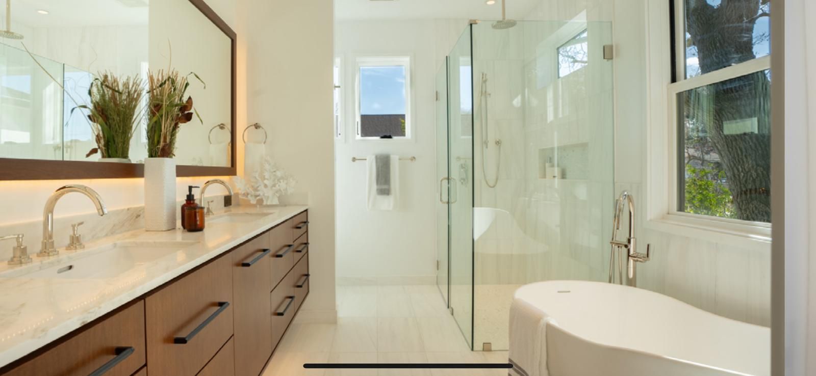 A bathroom with a toilet , sink , mirror and walk in shower.